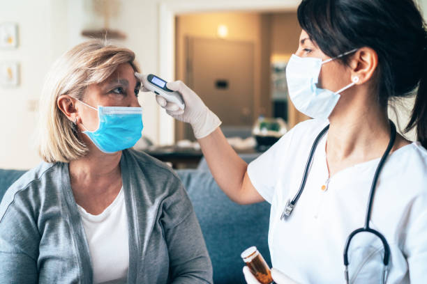 Female doctor doing medical exam to a senior woman at her home